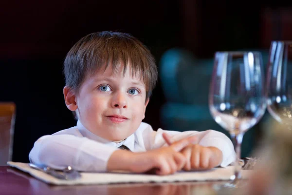 Söt liten knatte pojke på en fin restaurang — Stockfoto