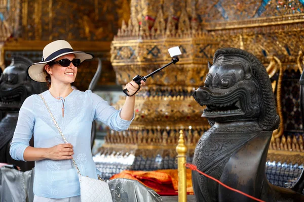 Молодая женщина в шляпе и солнцезащитных очках делает селфи в Большом дворце — стоковое фото