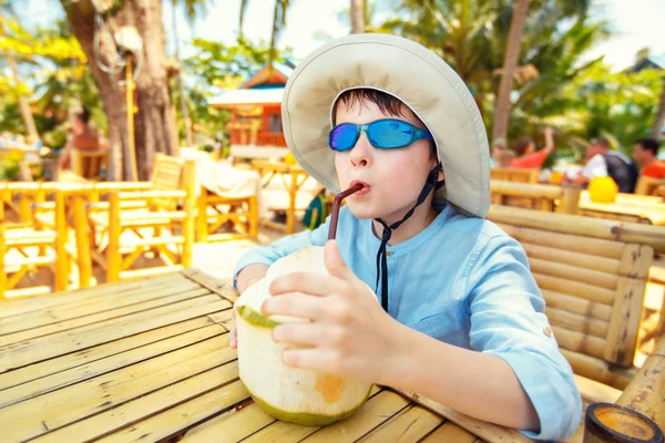 Lindo niño bebiendo cóctel de coco en el resort de playa tropical —  Fotos de Stock