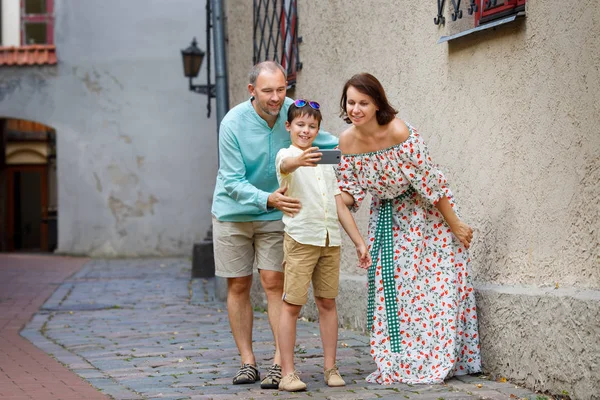 Gelukkige jonge familie Zelfportret met een mobiele telefoon maken in stad straat — Stockfoto