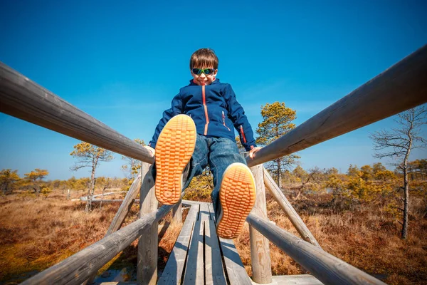Roztomilý malý kluk na stopě v bažině, národní park Kemeri, Lotyšsko — Stock fotografie
