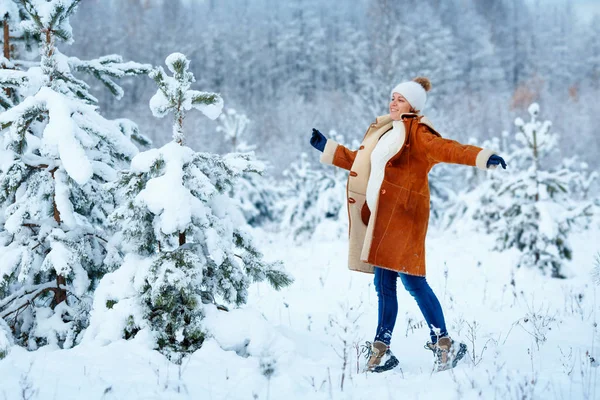 Young pregnant woman wearing warm clothes having fun on winter forest — Stock Photo, Image