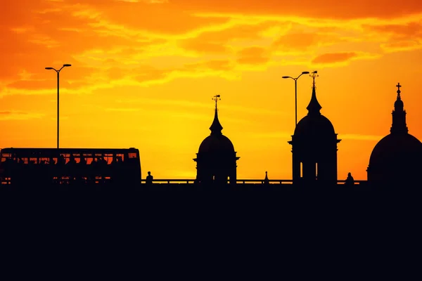 Pôr do sol formando uma silhueta de St. Paul, London Bridge e deckers duplos — Fotografia de Stock