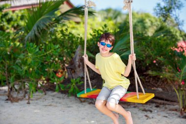 Sevimli çocuk eğleniyor tropik ada beach sallanan