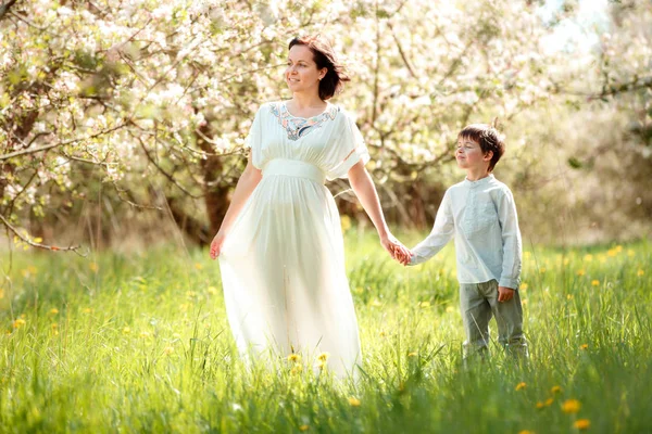 Young woman and her child having rest in spring apple garden — Stock Photo, Image