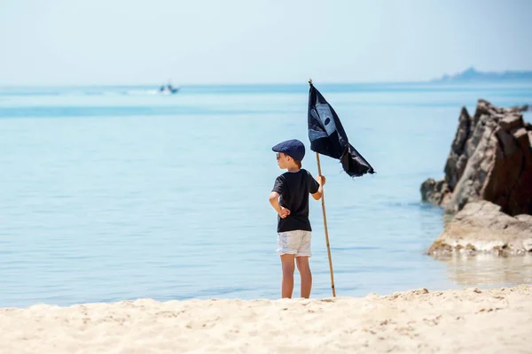 Ładny chłopiec przebrany za pirata na tropikalnej plaży — Zdjęcie stockowe