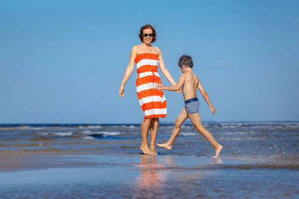 Мать и сын веселятся на пляже во время летних каникул — стоковое фото