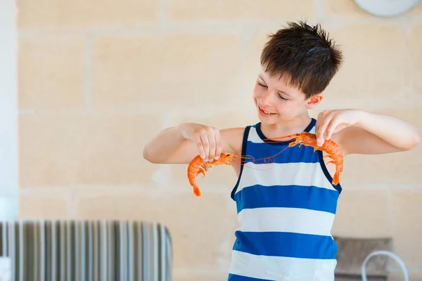 Lindo niño sosteniendo gambas grandes en las manos para la comida de hoy —  Fotos de Stock