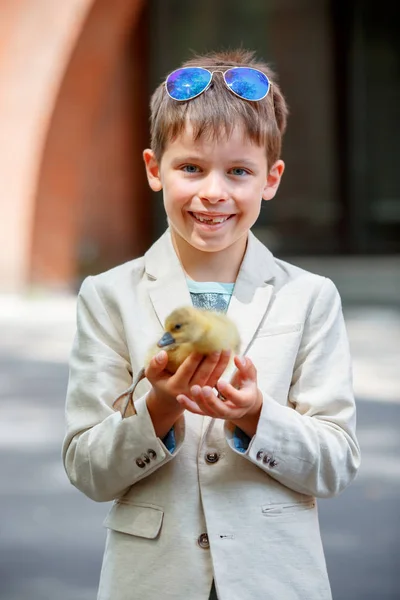 Cute little boy holding his pet baby goose — Stock Photo, Image