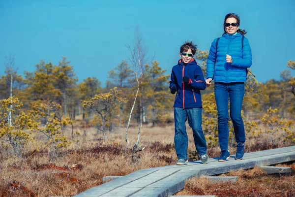 Menino bonito com a mãe andando na trilha no pântano, parque nacional Kemeri, Letónia — Fotografia de Stock