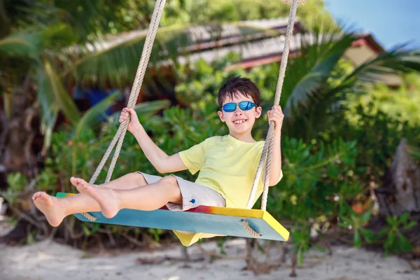 Ładny chłopak zabawy kołysanie na plaży tropikalnej wyspie — Zdjęcie stockowe