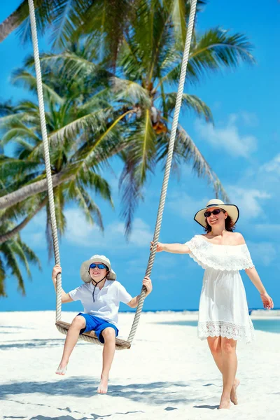 Jovem mulher bonita balançando filho em uma praia tropical, Koh Phangan ilha. Tailândia . — Fotografia de Stock