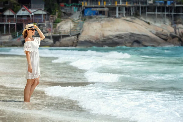 Frau in weißem Kleid spaziert am Strand — Stockfoto