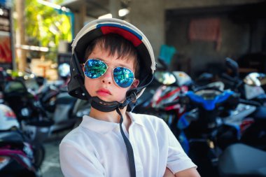 Portre sevimli küçük çocuk kask ve bir motosiklet sürme önce güneş gözlüğü
