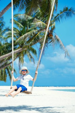 Sevimli çocuk eğleniyor tropik ada beach sallanan
