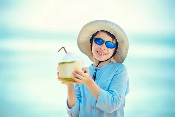 Μικρό αγόρι εκμετάλλευση καρύδας κοκτέιλ τροπική παραλία θέρετρο — Φωτογραφία Αρχείου
