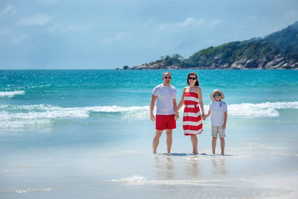 Νεαρή οικογένεια τριών διασκεδάζοντας τροπική παραλία — Φωτογραφία Αρχείου