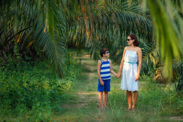 Jovem mulher e seu filhinho caminhando na floresta tropical — Fotografia de Stock