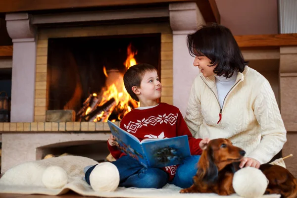 Mother and her little son by a fireplace at home — Stock Photo, Image