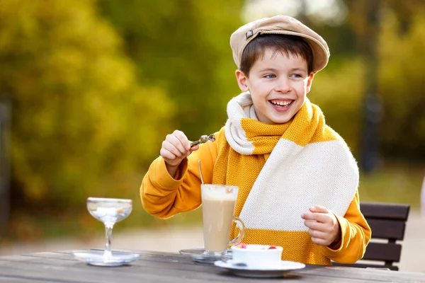 Cute little boy drinking hot chocolate in outdoor cafe — Stock Photo, Image