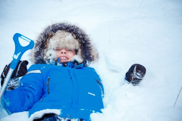 Cute little boy wearing warm clothes playing on winter forest — Stock Photo, Image