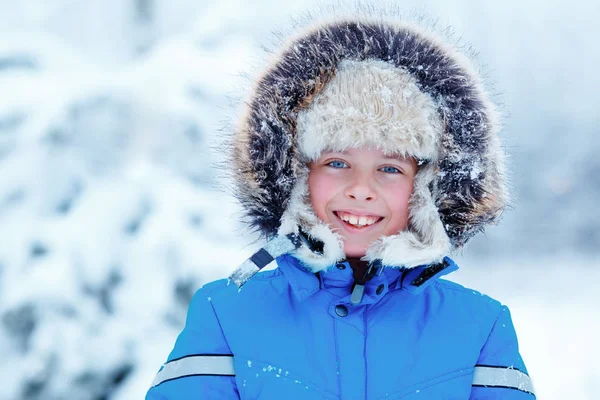 Bonito menino vestindo roupas quentes brincando na floresta de inverno — Fotografia de Stock