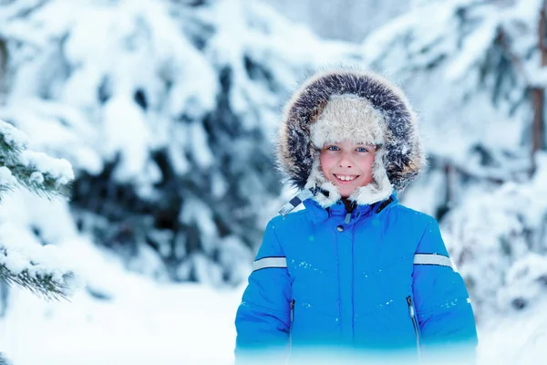 Lindo niño usando ropa de abrigo jugando en el bosque de invierno — Foto de Stock