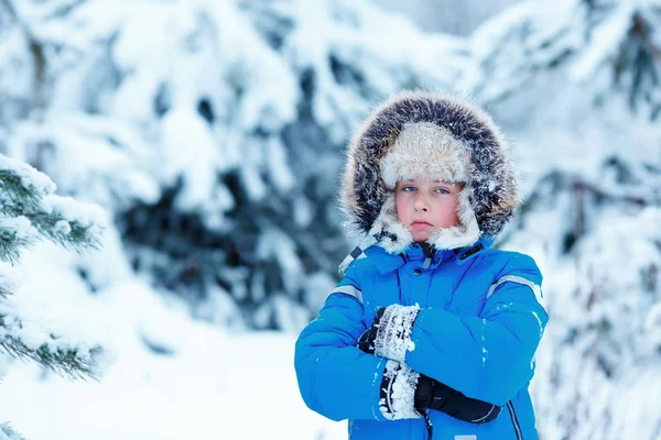 Cute little boy wearing warm clothes playing on winter forest — Stock Photo, Image