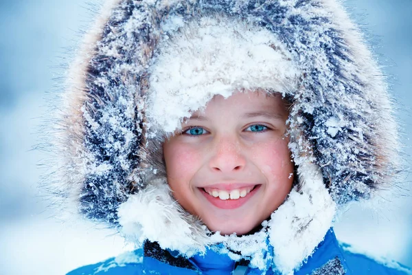 Söt liten pojke som bär varma kläder spelar på vintern skog — Stockfoto