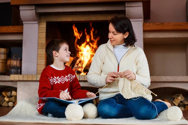 Mother and her little son by a fireplace at home Royalty Free Stock Images