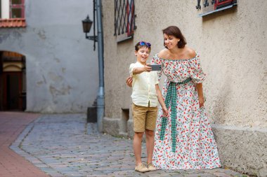 Genç anne ve oğlu ile bir cep telefonu kendi kendine portre şehirde sokak yapma
