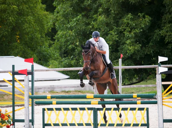 Ruiter met paard over de hindernis tijdens springen wedstrijd — Stockfoto