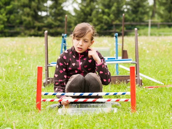 Girl behind hurdle for rabbit — Stock Photo, Image