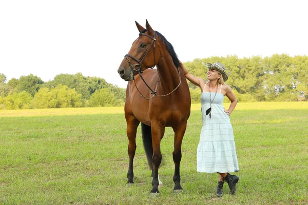 马在牧场草帽的女人 — 图库照片