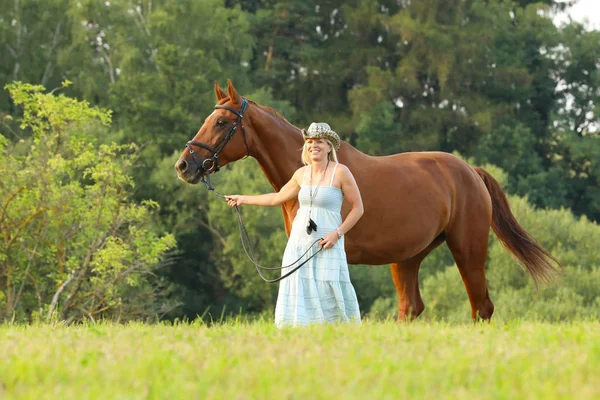 処理の帽子の女は 夏の午後に手綱で馬を導く — ストック写真