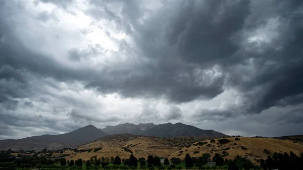 Dramatic storm clouds rolling overhead towards Timpanogos Mountain in Utah.