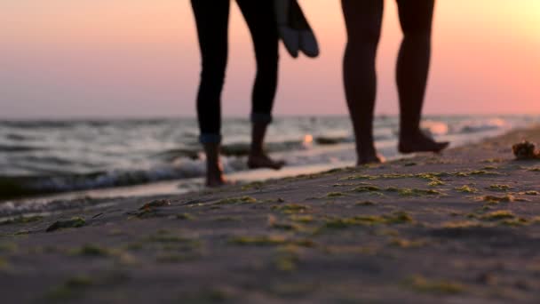 Dziewcząt spaceru na plaży boso o zachodzie słońca — Wideo stockowe