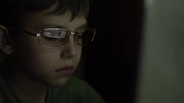 Un ragazzo con gli occhiali gioca un gioco su un computer . — Video Stock