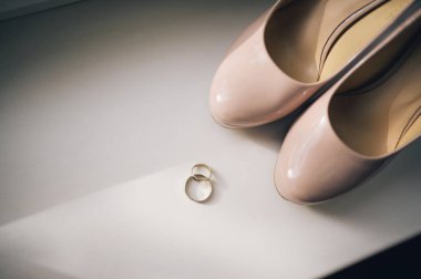 Alyans, beyaz arka planlı zarif beyaz ayakkabı