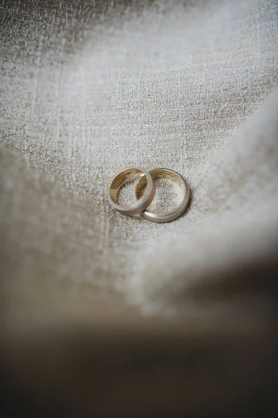 Anillos de boda sobre tela de fondo marrón claro — Foto de Stock