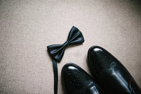 Крупным планом облегчен с естественным легким черные туфли и бабочка для жениха — стоковое фото