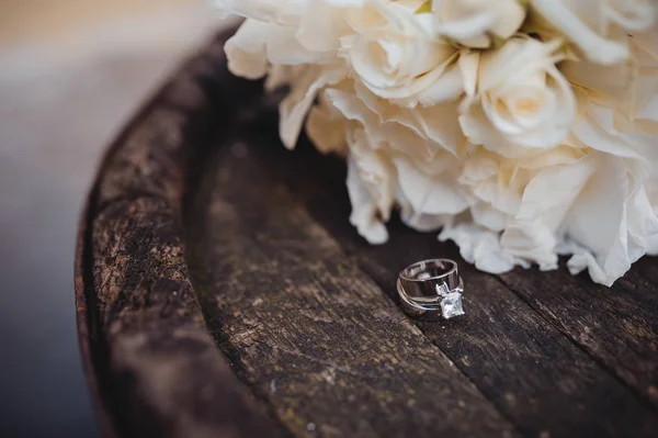 Primer plano de los anillos de joyería de boda, flor sobre fondo de madera — Foto de Stock