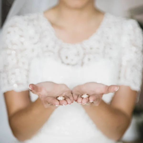 Обручальные кольца в руках невесты — стоковое фото