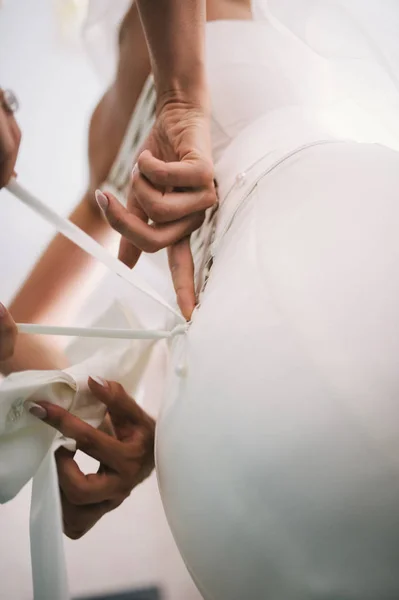 Madre mano encaje corsé en la delicada cintura de la novia — Foto de Stock