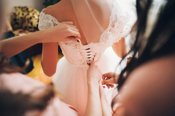 Les mains lacent le corset sur la taille délicate de la mariée — Photo