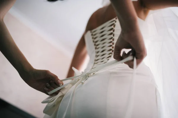 Manos encaje corsé en la delicada cintura de la novia — Foto de Stock