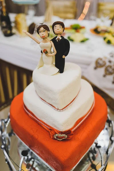 Funny figurines at a luxury wedding white cake In the form of a heart