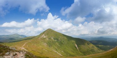 Mavi yaz göğün altında yeşil dağ