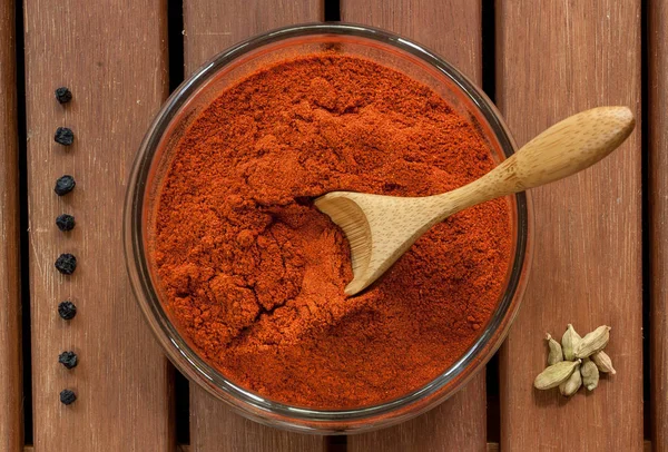 Piros paprika, egy pohár, egy fából készült asztal — Stock Fotó