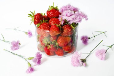 Pembe çiçek bir buket ile cam fincan olgun çilek 